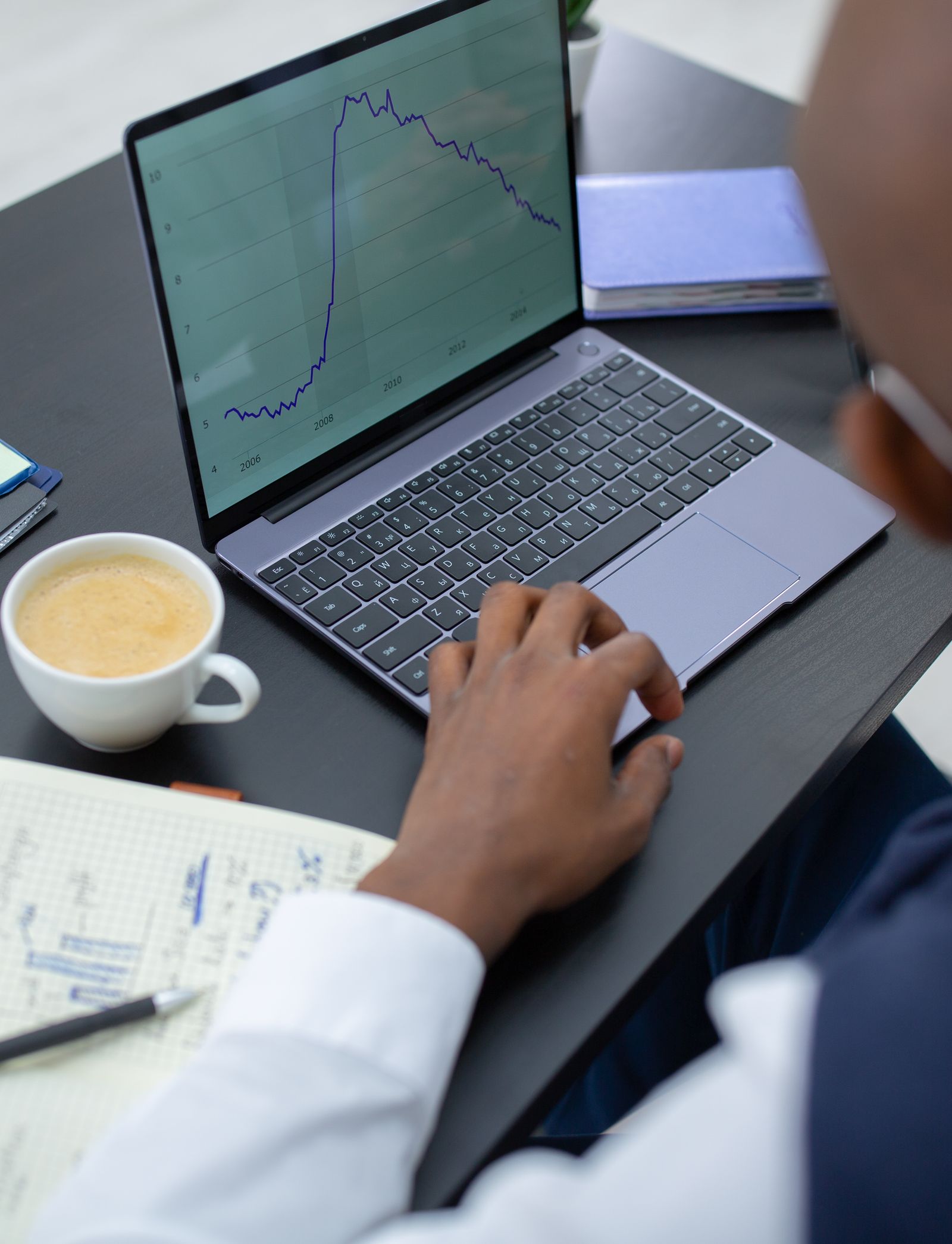 Analyst arbeitet mit Finanzdiagrammen auf einem Laptop